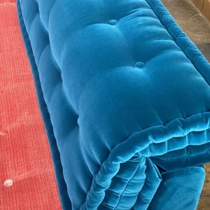 Detail of deep blue and coral pink velvet cushions on a Mah Jong-style sofa, showcasing its modular design.