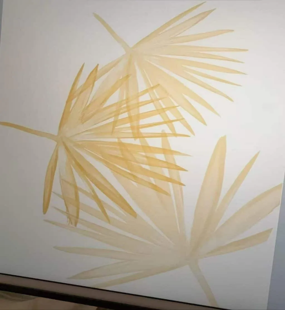 Hand-painted golden palm fronds on a cream background, shown on screen during design development
