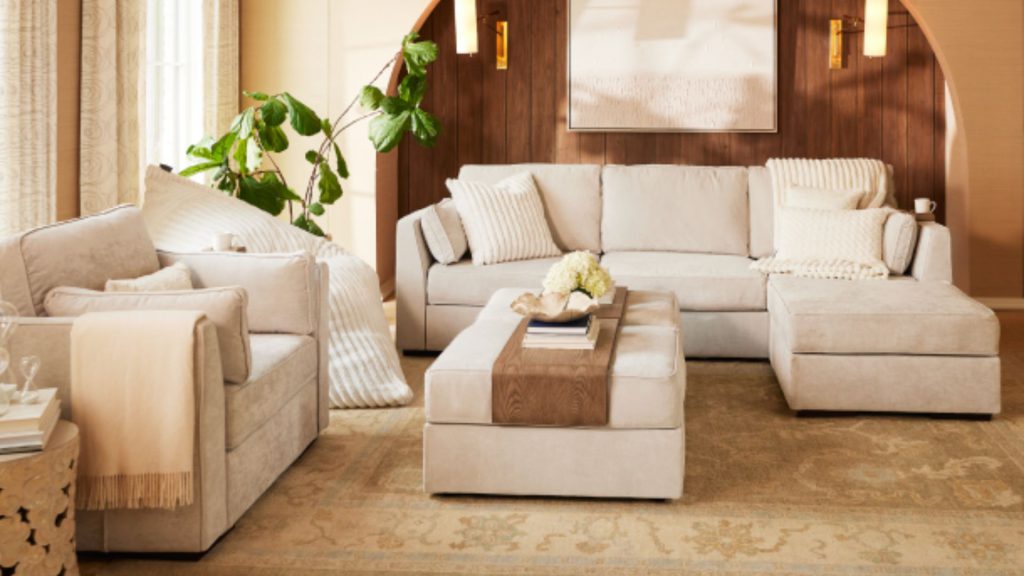 Neutral modular Lovesac custom sectional sofa in a modern living room with plush cushions and a large ottoman.