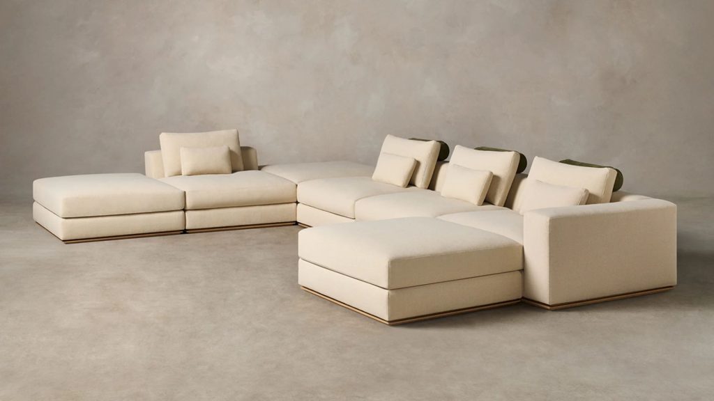 Maiden Home custom modular sectional sofa in soft cream upholstery and a minimalist studio backdrop.