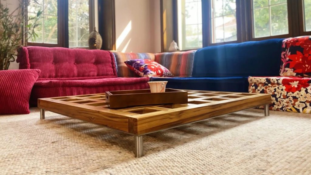 Sectional sofa styled with a low coffee table, vibrant pillows, and a decorative tray.