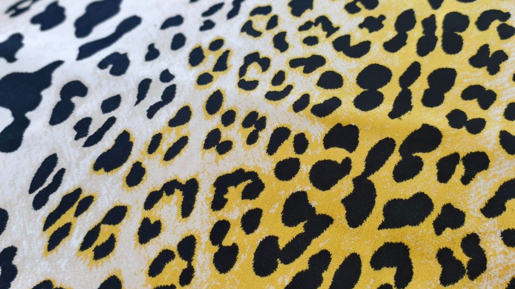 Close-up of yellow leopard-patterned sofa fabric.