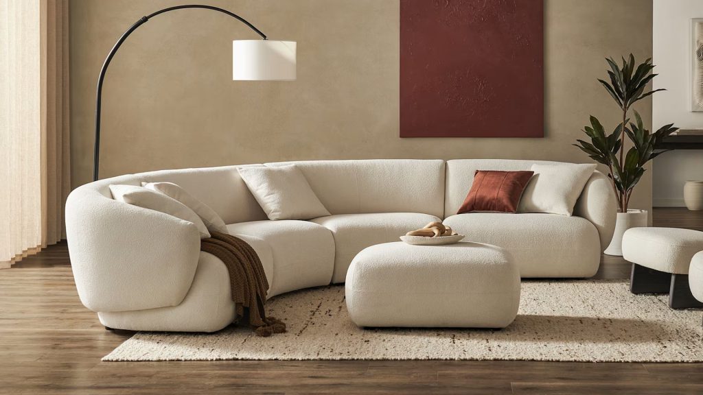 Castlery’s Auburn Curve L-Shape Sectional in a comfy living room and a sectional in the center.