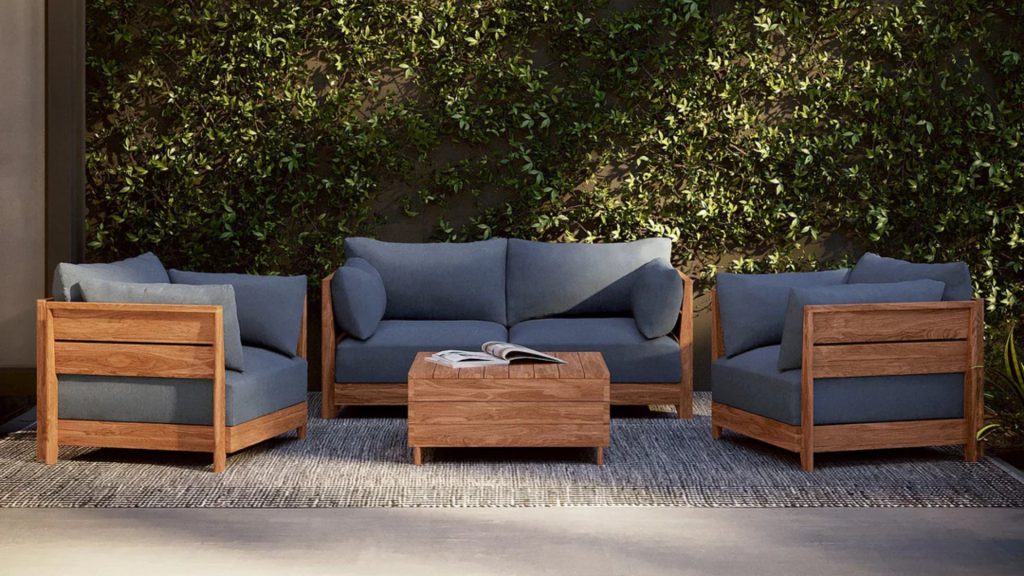 Chicory's Modular Teak Outdoor Sofa in dark blue upholstery.