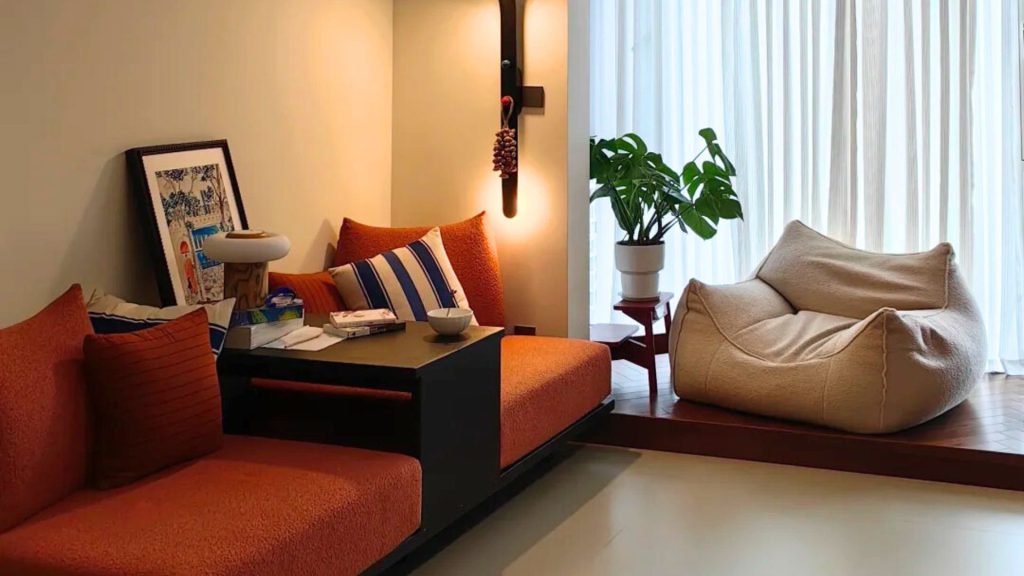 Orange pet-friendly sofas with a beige single-seater sectional furnished in a living room.