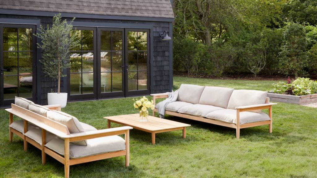 Design Within Reach's Terassi Sofa in a backyard paired with a wooden table.