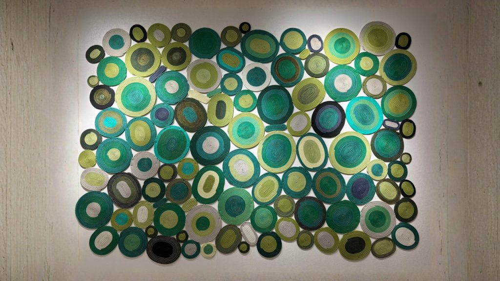 Adorn Croft's wall rug in a green palette with circular shapes.