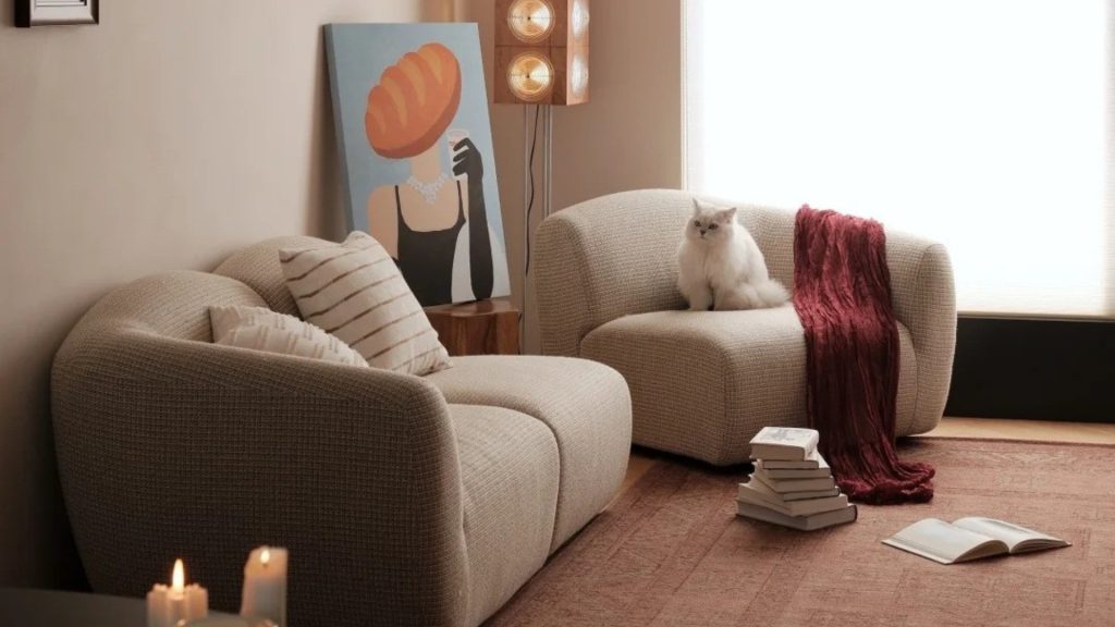A white cat on a corner sectional.