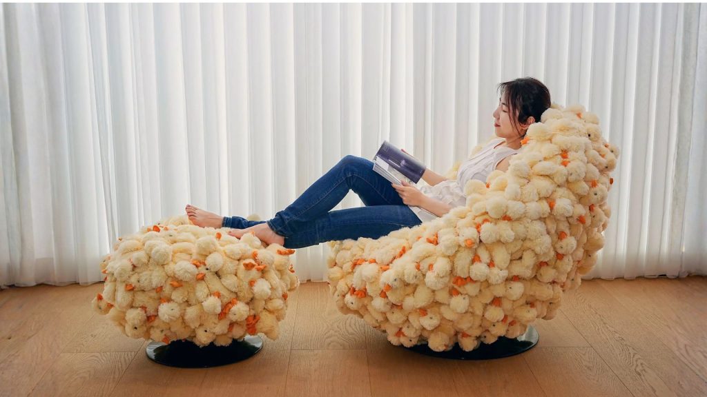 A lady lounging with a book on Adorn Croft's duck egg chair.