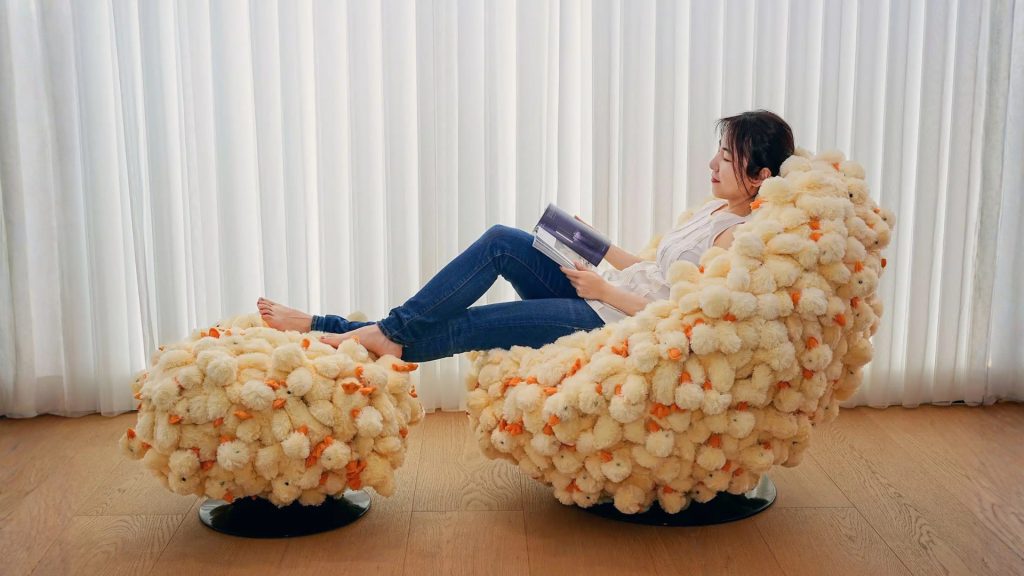 A lady lounging with a book on Adorn Croft's duck egg chair.
