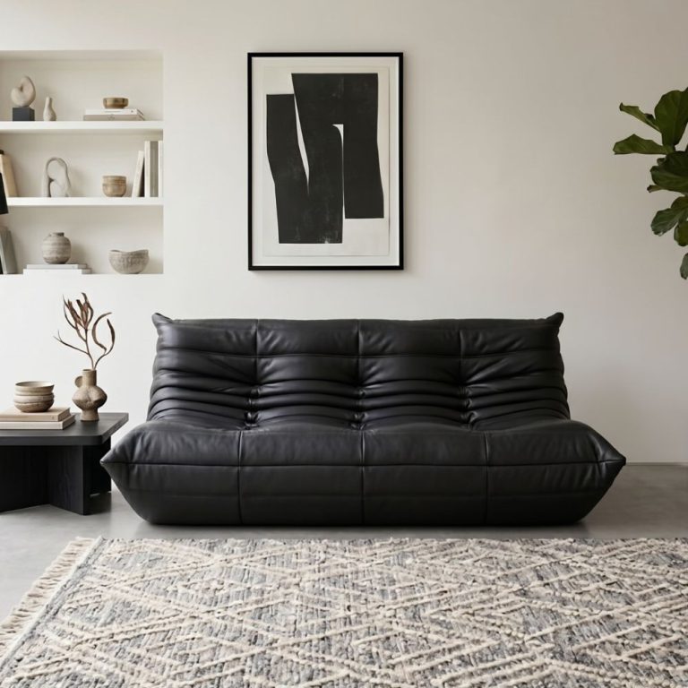 A black leather togo loveseat in a room.