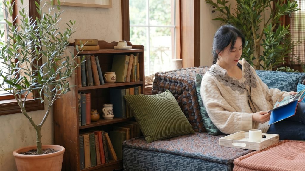 Lady reading on a colorful couch.