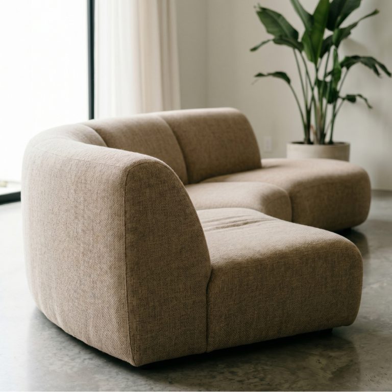 A rounded sofa in a neutral fabric.