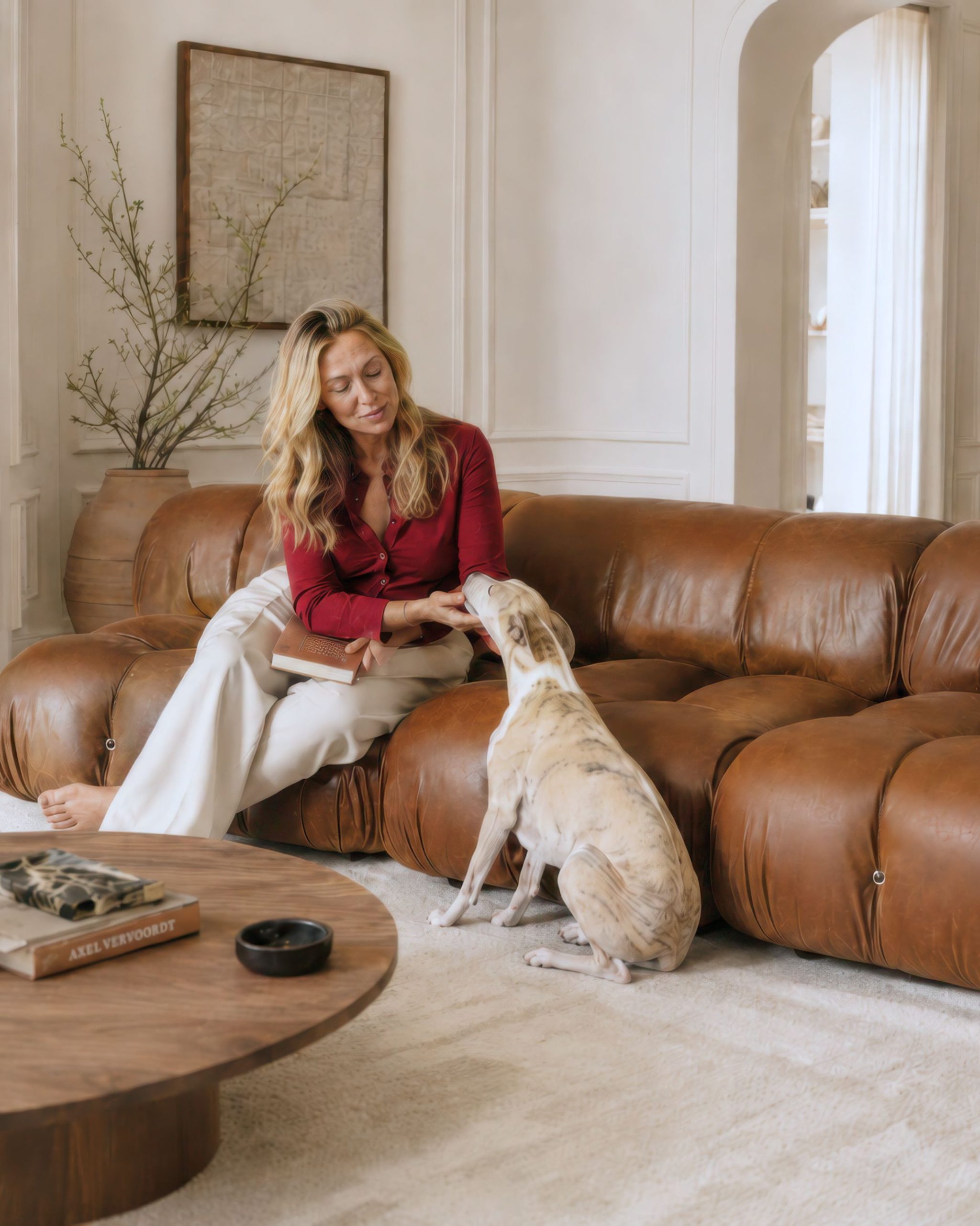 Woman and dog on a tan top-grain leather Mario Bellini sectional sofa in a contemporary living room