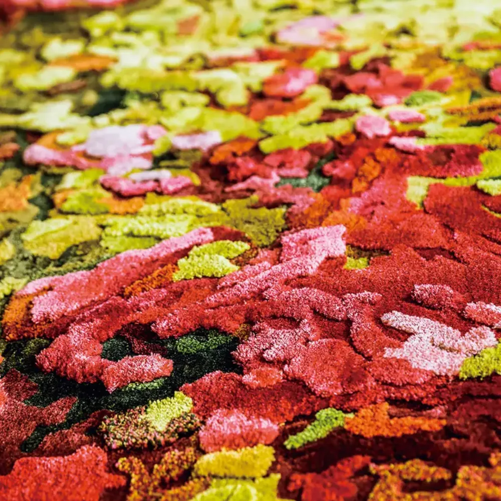 Close-up of a dense, plush pile bamboo silk carpet in a red and green floral pattern