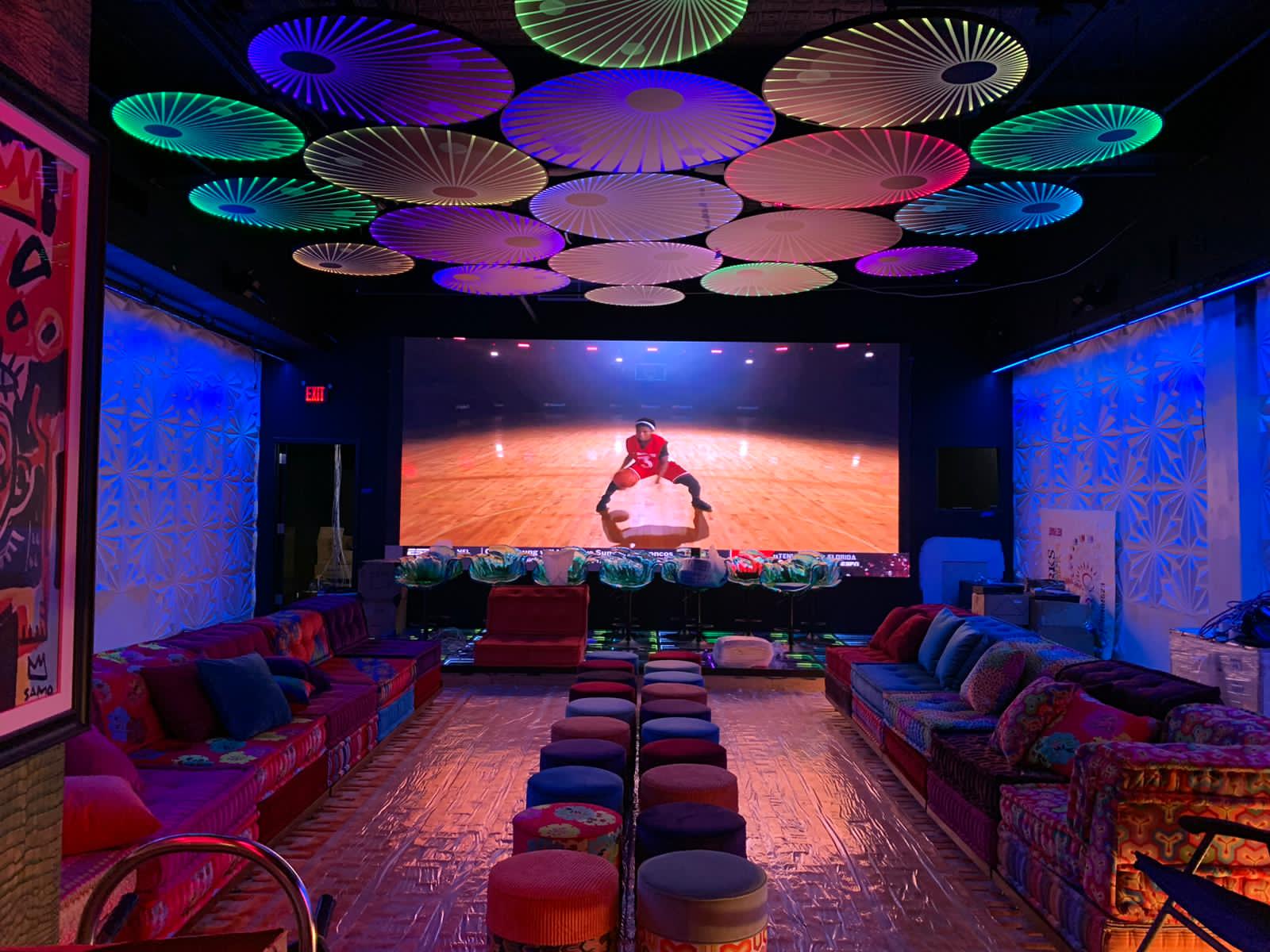 Custom Mah Jong sofa in a colorful public bar with layered circular ceiling lighting and bar seating