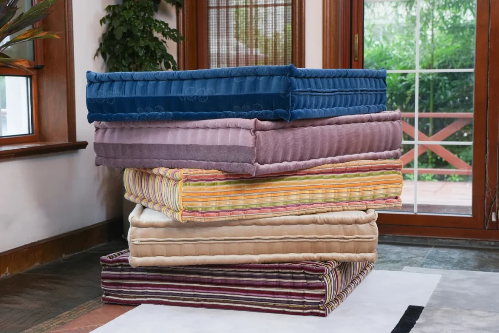 stack of colorful modular sofa cushions in velvet and striped fabrics