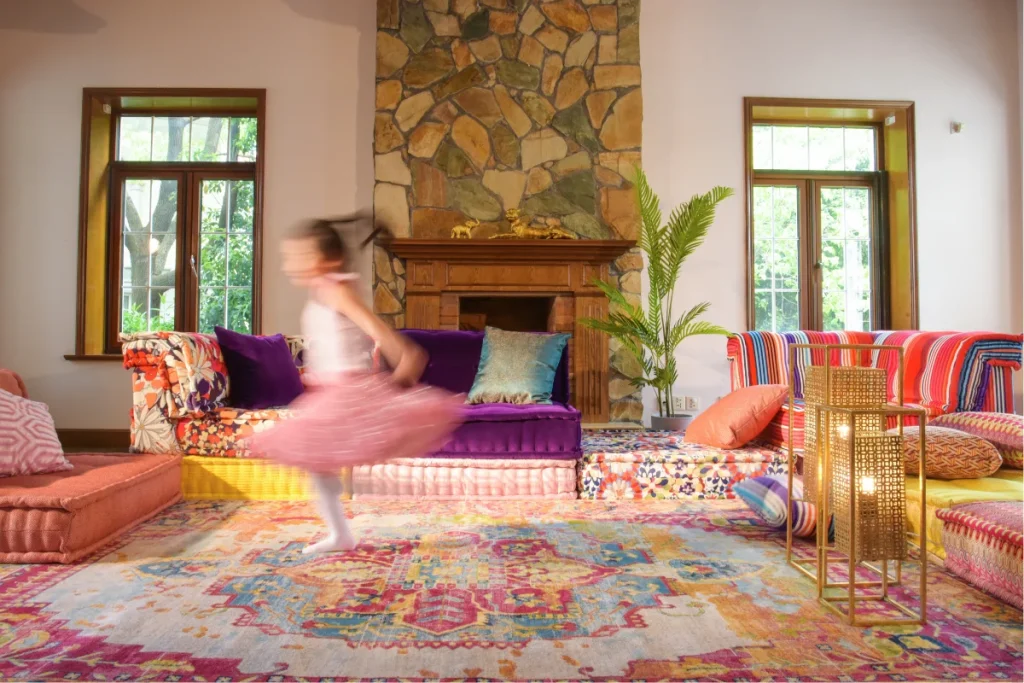 Little girl running across a living room with a colorful sofa set up