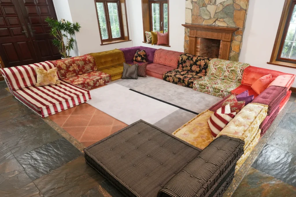 large U-shaped colorful modular sofa arrangement filling a living room with a fireplace