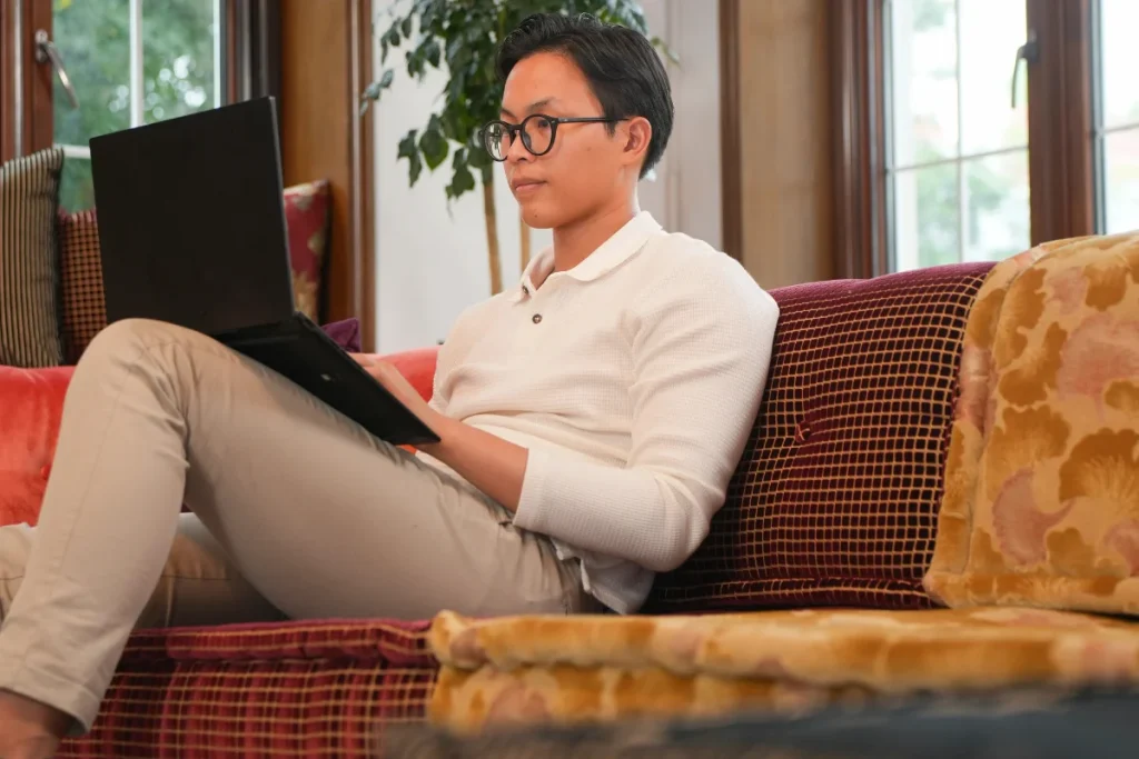 Man sitting with a laptop on a colorful modular sectional sofa