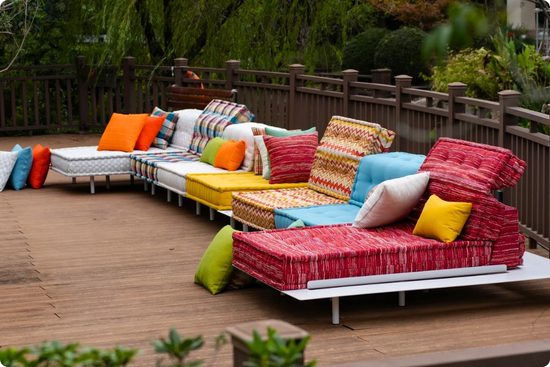Vibrant outdoor colorful sofa on a white aluminum base on a patio.